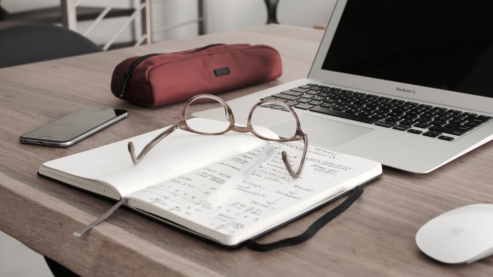 A laptop and open notebook on a desk, ready for a virtual conversation
